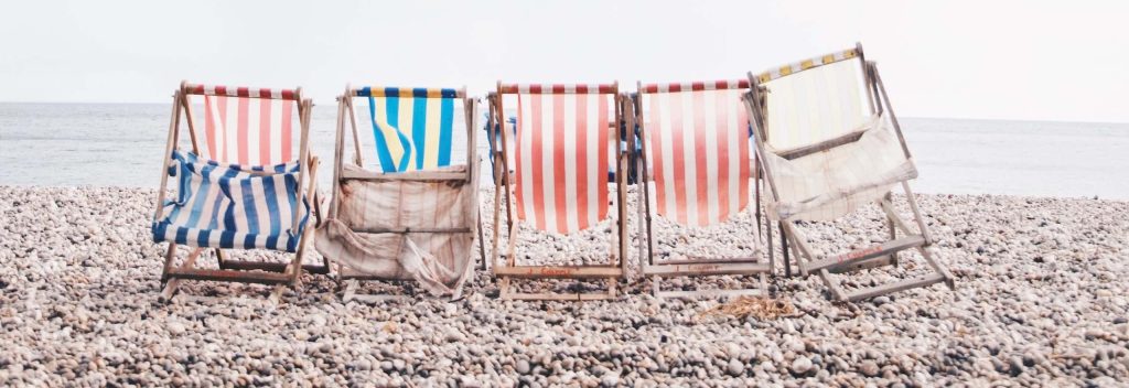 5 deck chairs on a beach